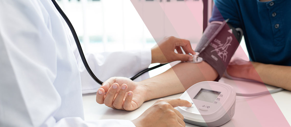 Clinician checking a patient's blood pressure with an arm cuff and stethoscope